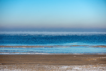 frozen sea beach in winter with low snow coverage