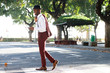 © mimagephotos - Full length smiling young black man in suit walking with mobile phone on street