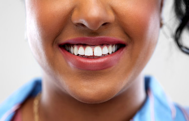 oral care, dental hygiene and people concept - close up of african american woman face with smile and white teeth