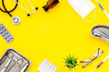 Medicine help with drugs frame on work desk of doctor yellow background top view mock up