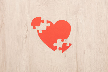 Wall Mural - top view of bright paper heart and pieces of puzzle on wooden background