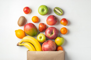 Wall Mural - Paper bag of different health fruits on a table.