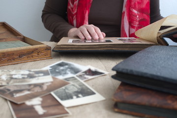 Midsection of the woman at the table looking at the vintage memories