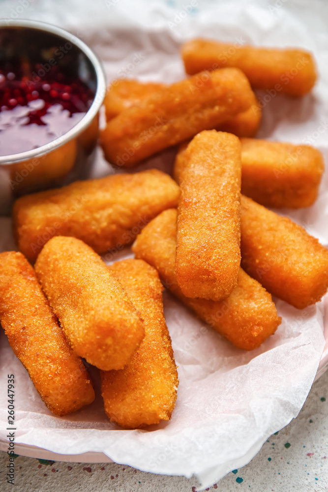 Tasty mozzarella sticks with jam on white table, closeup
