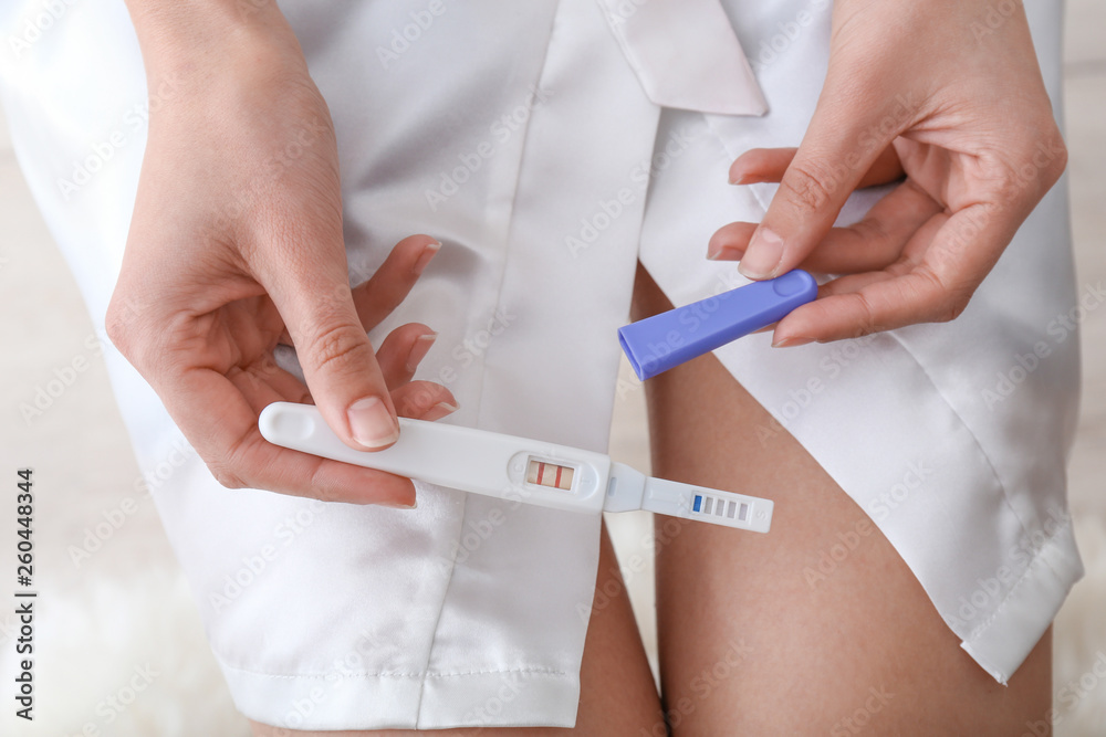 Woman with pregnancy test, closeup