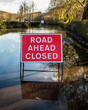 'Road ahead closed' UK road sign, flooded road.