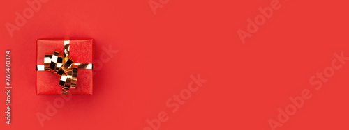 Red gift box on red background.