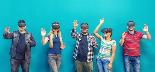 Group of friends using new technology playing on vr glasses indoor – virtual reality with people having fun together 