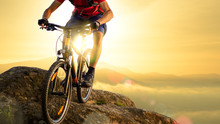 Cyclist In Red Riding The Bike Down The Rock At Sunrise. Extreme Sport And Enduro Biking Concept.