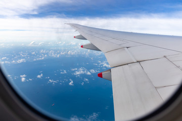 Selective focus Airplane wing view out of the window the cloudy sky background, Travel and Holiday vacation concept