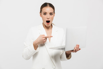 Wall Mural - Beautiful shocked excited amazing woman posing isolated over white wall background using laptop computer.