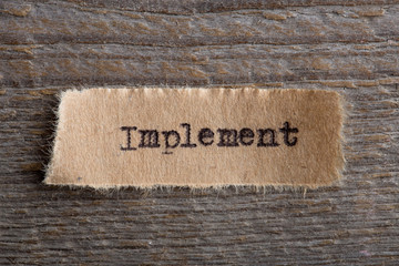 Implement - word on a piece of paper close up, business creative motivation concept