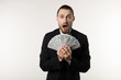 © Vasya - Portrait of shoked handsome businessman wearing black suit showing money banknotes