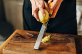 Fototapeta  - Female chef grating lemon zest on a wooden board