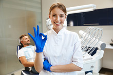 Beautiful Happy Young Woman Doctor In Medical Dentist Center Showing Okay Gesture.