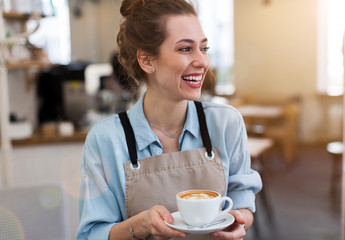 Wall Mural - woman in cafe with cup of coffee in her hands