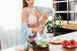 © LIGHTFIELD STUDIOS - Cropped view of sexy young woman in underwear and shirt seasoning vegetable salad
