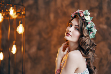 Beautiful young woman with wreath of flowers in her hair