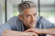 © goodluz - Portrait of handsome mature man looking at camera in contemporary home