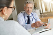 © goodluz - Doctor going through results with patient in clinic office