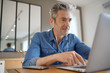 © goodluz - Mature man on video call working from home