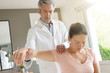 © goodluz - Physiotherapist helping patient with shoulder injury