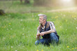 © goodluz - Mature man crouched in field in countryside