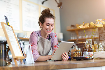 Wall Mural - young woman using digital tablet in coffee shop