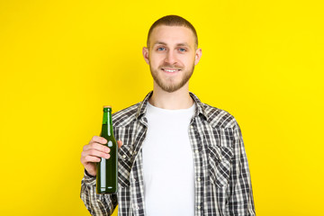 Poster - Young man with bottle of beer on yellow background