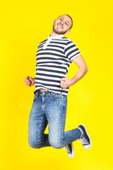 Poster - Jumping young man on yellow background