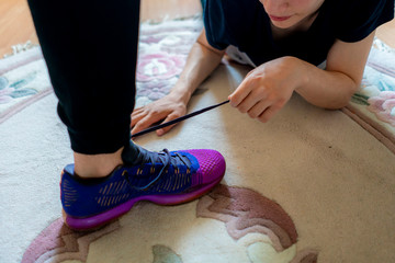 young man tying shoelaces of his friend to each other b