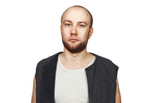 Portrait Young Bald Guy With Beard With Pocker Face Dressed In Sleeveless Shirt. Isolated On White Background.