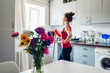© maryviolet - Young housewife washing floor with mop in modern kitchen decorated with flowers. Household chores