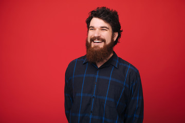 Wall Mural - A smiling man over red background looking far away