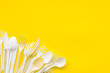 Plastic utilization concept with flatware on yellow background top view mock up