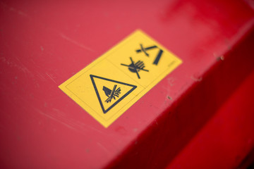 Yellow warning label on a red lawn mower