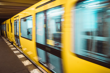 Yellow blurred subway train in Berlin. Public U-bahn transport in underground station interior