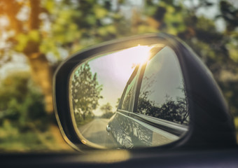 Wall Mural - Car side mirrors with natural road travel in warm sunlight.