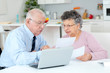 © auremar - senior couple using laptop computer at home