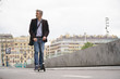 © goodluz - Businessman on daily commute riding micro scooter