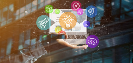 Poster - businessman holding a cloud of colorfull start up icon bubble with a laptop 3d rendering