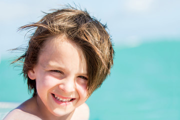 Wall Mural - Close portrait of cute smiling preschool child enjoying day trip with speed boat