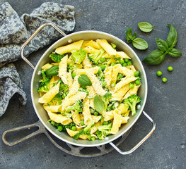 Wall Mural - penne pasta with spinach pesto sauce, green peas and broccoli, top view