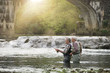 © goodluz - Fly fishing expert guiding novice in river
