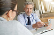 © goodluz - Doctor going through results with patient in clinic office