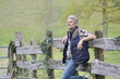 © goodluz - Farmer leaning on fence outside his field