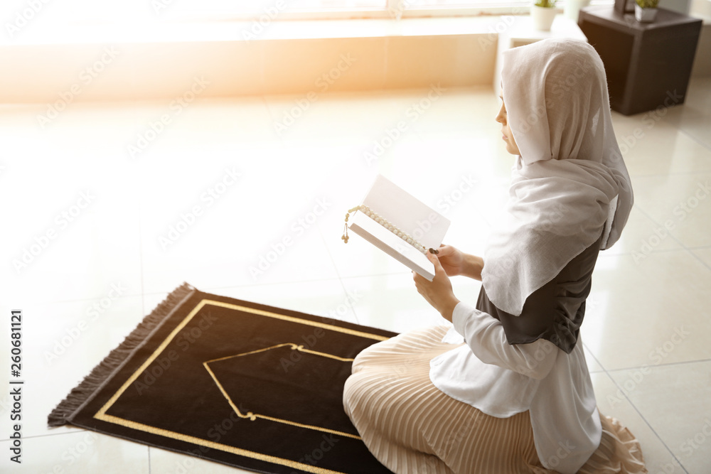 Young Muslim woman praying at home