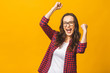 © denis_vermenko - Winning success woman happy ecstatic celebrating being a winner. Dynamic energetic image of multiracial Caucasian Asian female model isolated on yellow background waist up.