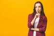© denis_vermenko - Portrait of a pretty serious woman in casual posing isolated on a yellow background.