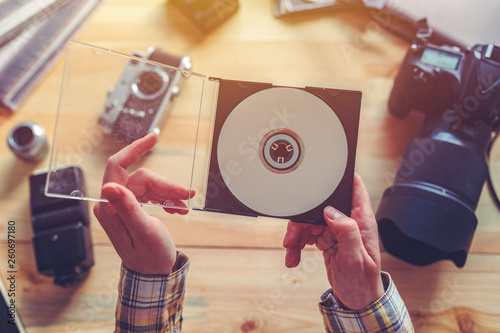 Photographer holding dvd disc with archived photos